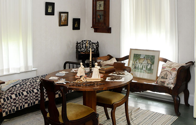 Interior of W. W. Mayo House showing a table set with dolls.